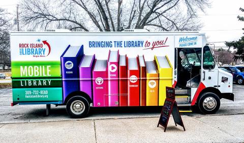 Picture of the side of the mobile library showing the library's logo and colorful book spines.