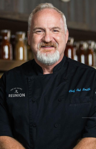 Head and shoulders shot of author and chef Art Smith, wearing black chef's coat