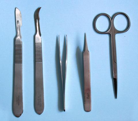 Five metal dissection tools on a blue background.