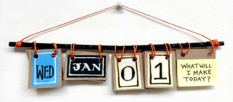 A flip calendar. Cards reading "Wed", "Jan", "0", "1" and a post-it pad are secured to a dowel with twine