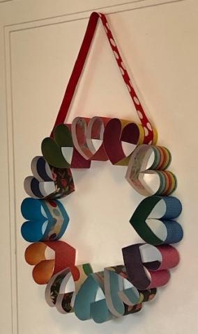 Creat hearts with colorful papers and attach them to form a wreath for Valentine's day.