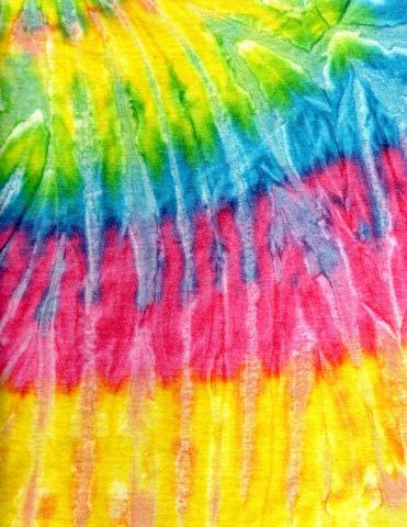 A picture of tie dyed cloth with yellow, green, blue, and pink sections. 