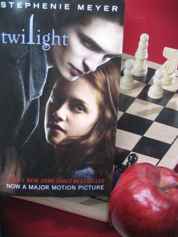 Picture of Twilight (the book) in front of a chess set with apple. 