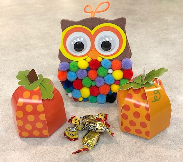 Using pom-poms create a cute owl ornament and put a few treats in little pumpkin treat boxes.
